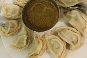momo Nepalese dumplings on plate with dipping sauce