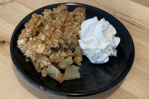 apple crumble on a plate with whipped cream